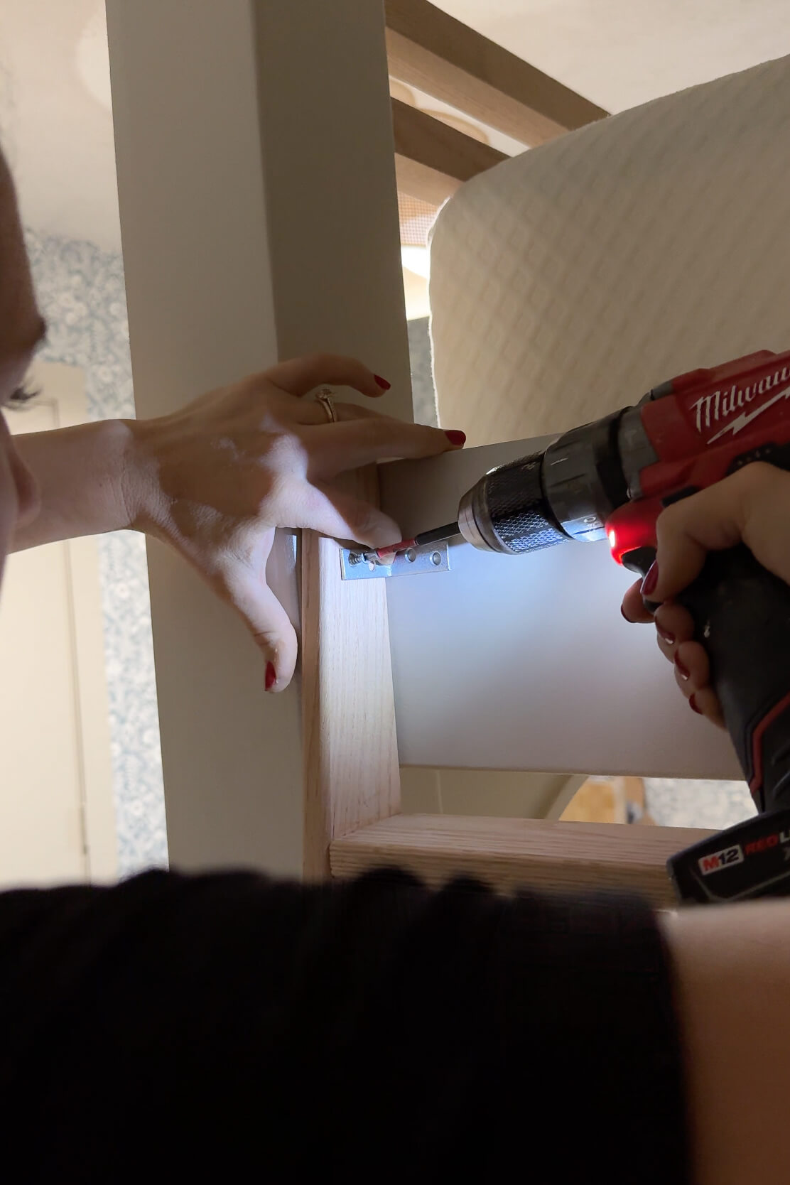 Using angle brackets to attach a ladder to a DIY bunk bed.